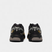 Saucony ProGrid Omni 9 Black Gold, sneaker running rétro noire et dorée en mesh avec empiècements techniques et semelle à technologie Grid vue de derrière. 