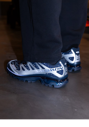 Fruit d’une collaboration marquante entre Salomon et le retailer japonais atmos, la XT-4 OG Gore-Tex atmos Stars Collide II célèbre la rencontre entre performance outdoor et culture street internationale. Cette édition spéciale revisite l’un des modèles trail les plus emblématiques de la marque à travers une vision audacieuse et conceptuelle, où technicité extrême et narration visuelle se répondent avec précision.

