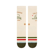 Paire de chaussette beige à motif avec un ours de couleur verte et une inscription "CALIFORNIA" au dessus de couleur marron claire, la paire de chaussettes est vue de dessus