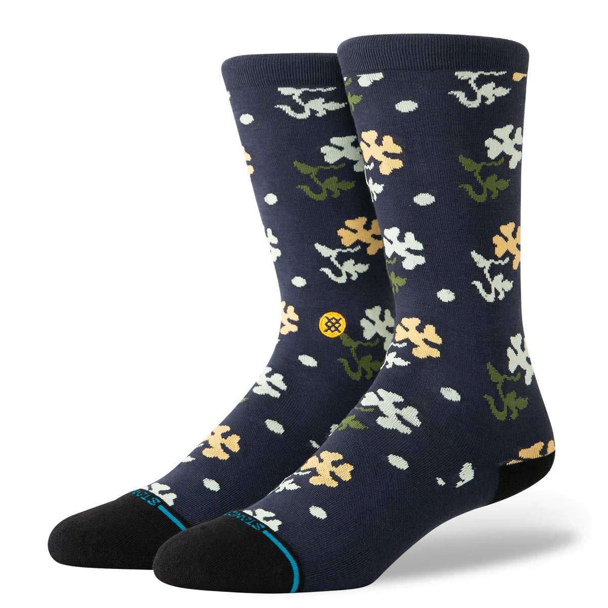Paire de chaussette bleu marine à motif fleurs vert, blanc et jaune. La paire de chaussette est vue de 3/4 face