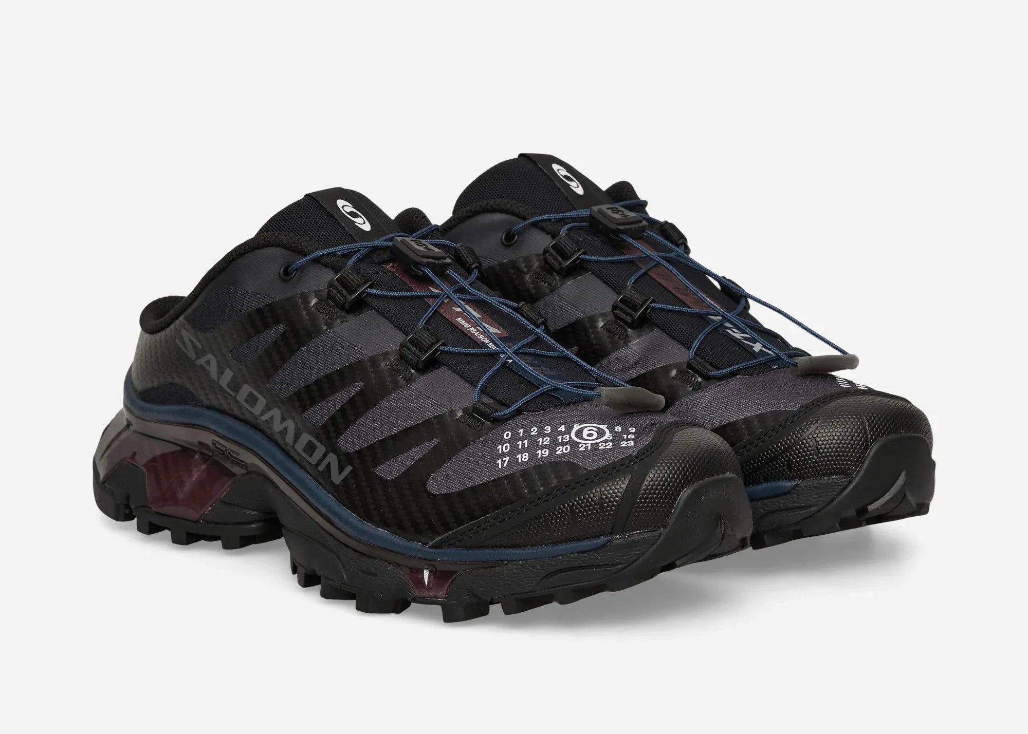 Salomon XT-4 Mule MM6 Maison Margiela Black Nine Iron en mesh noir et gris anthracite avec système Quicklace et construction ouverte au talon.