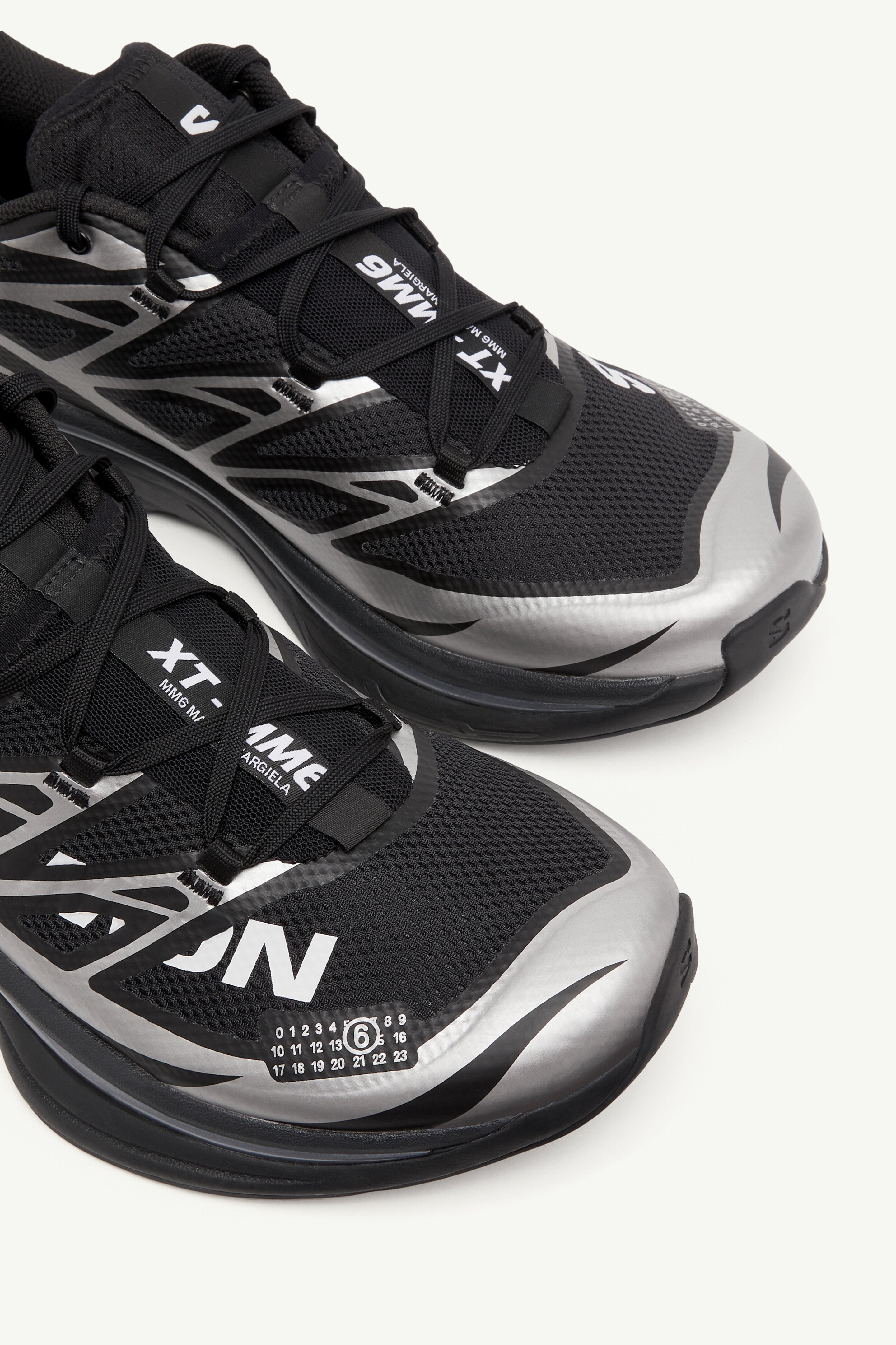 Image de la Salomon XT-6 MM6 Maison Margiela Black Silver, sneaker noire et argentée en mesh technique, détails TPU brillants, semelle Contagrip®, laçage Quicklace. Zoom avant