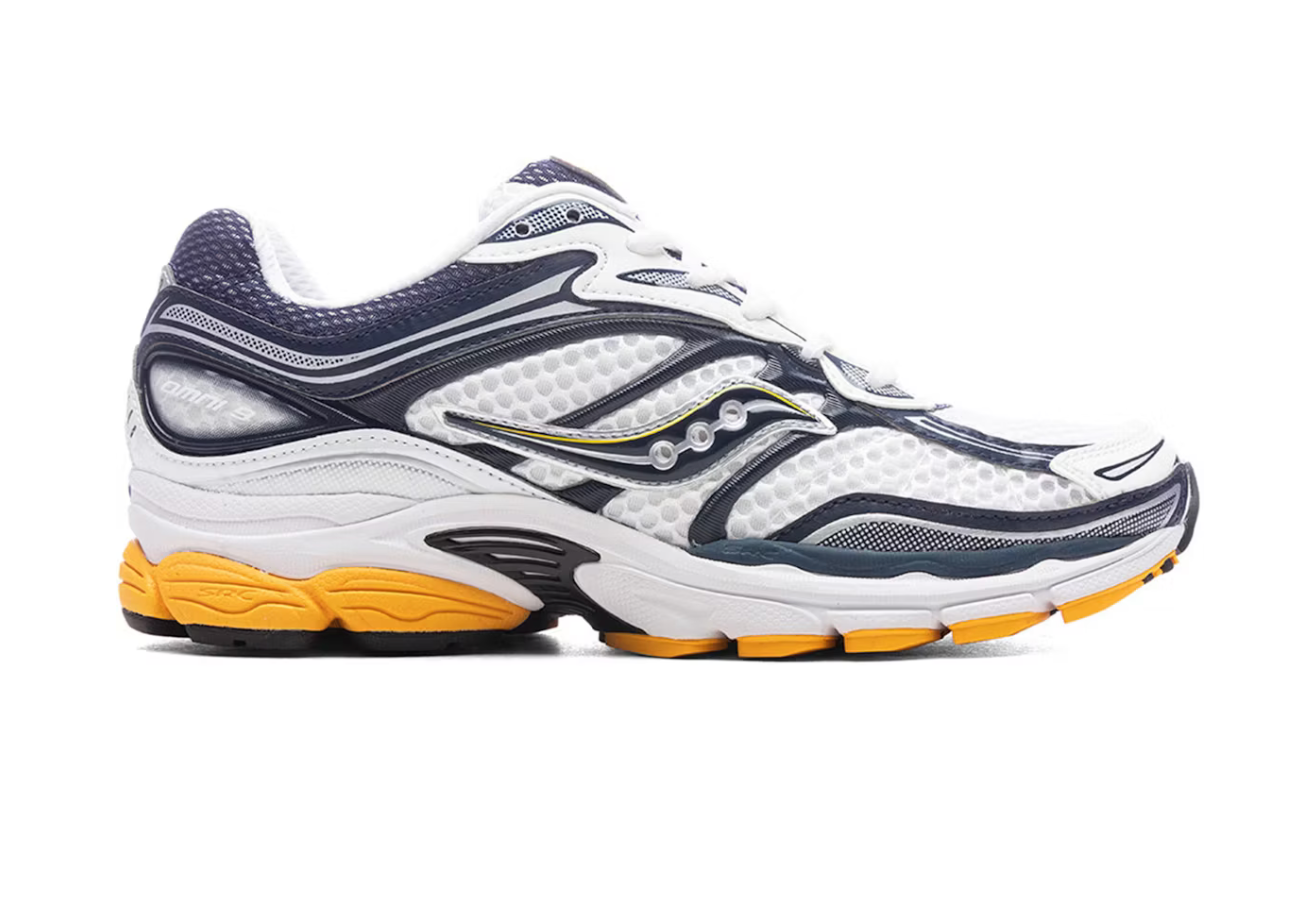 Saucony ProGrid Omni 9 White Navy Yellow en mesh blanc avec détails bleu marine et jaunes, amorti ProGrid vue de profil. 