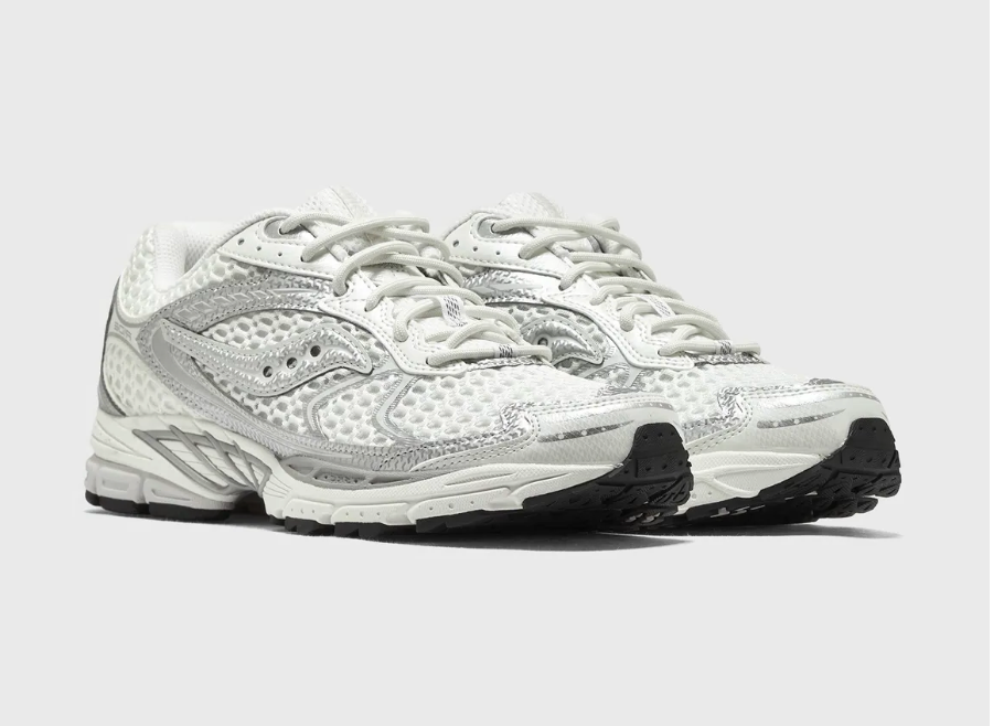 Saucony ProGrid Ride 1 Ivory Silver avec tige en mesh respirant, empiècements synthétiques ivoire et argent métallisé, technologie ProGrid et semelle extérieure en caoutchouc.