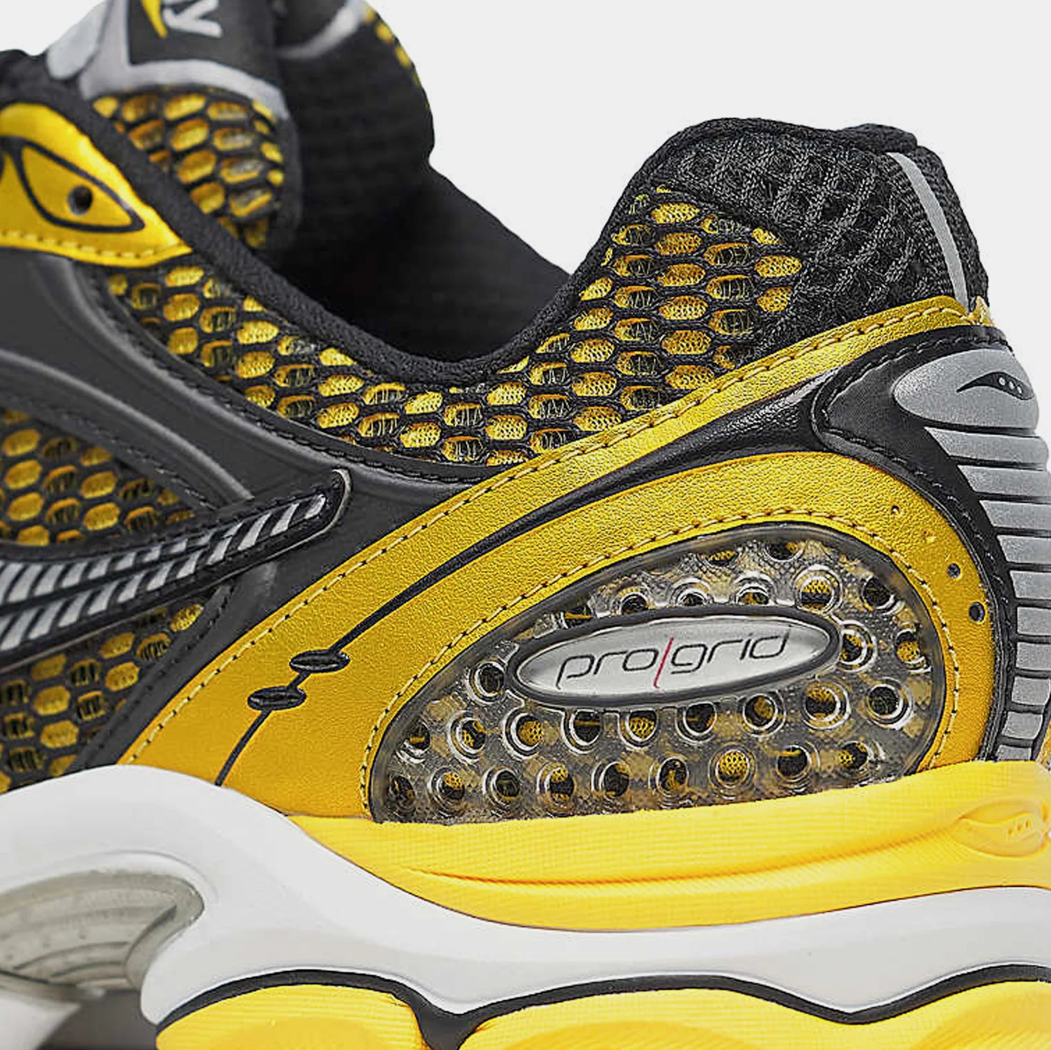 Saucony ProGrid Triumph 4 Lemon Chrome en mesh blanc avec superpositions jaune métallisé et amorti ProGrid.