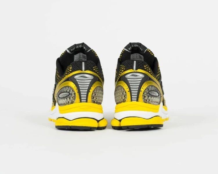 Saucony ProGrid Triumph 4 Lemon Chrome en mesh blanc avec superpositions jaune métallisé et amorti ProGrid.