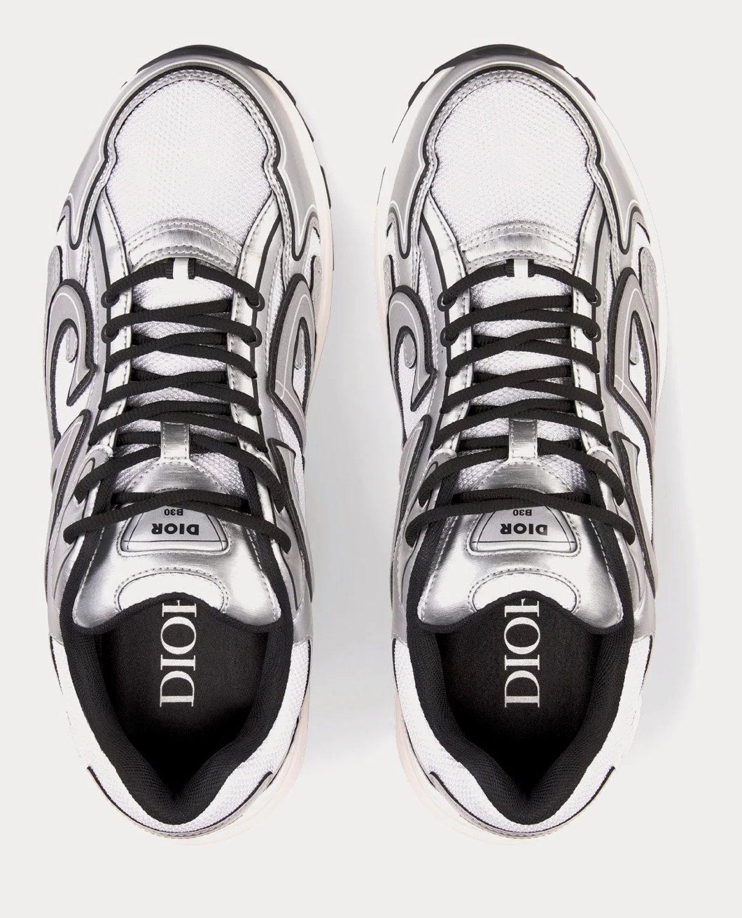 Dior B30 White Mesh Silver-Tone Metallic Calfskin avec tige en mesh blanc respirant, empiècements en cuir de veau métallisé argenté et silhouette running moderne.