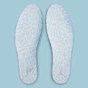 Vue zoomée sur les semelles intérieures de la Air Jordan 13 Retro SoleFly DX5763-100 en suède et ripstop blanc, gris et bleu ciel avec hologramme cat’s eye et semelle gum.