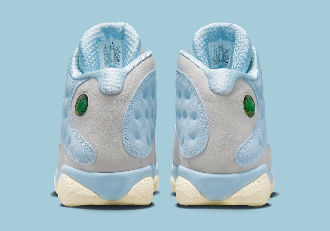 Air Jordan 13 Retro SoleFly DX5763-100 en suède et ripstop blanc, gris et bleu ciel avec hologramme cat’s eye et semelle gum vue de derrière. 