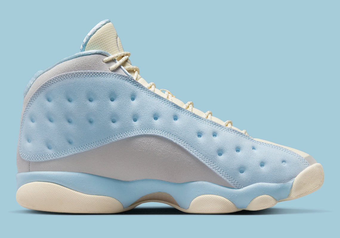 Air Jordan 13 Retro SoleFly DX5763-100 en suède et ripstop blanc, gris et bleu ciel avec hologramme cat’s eye et semelle gum vue de profil intérieur. 