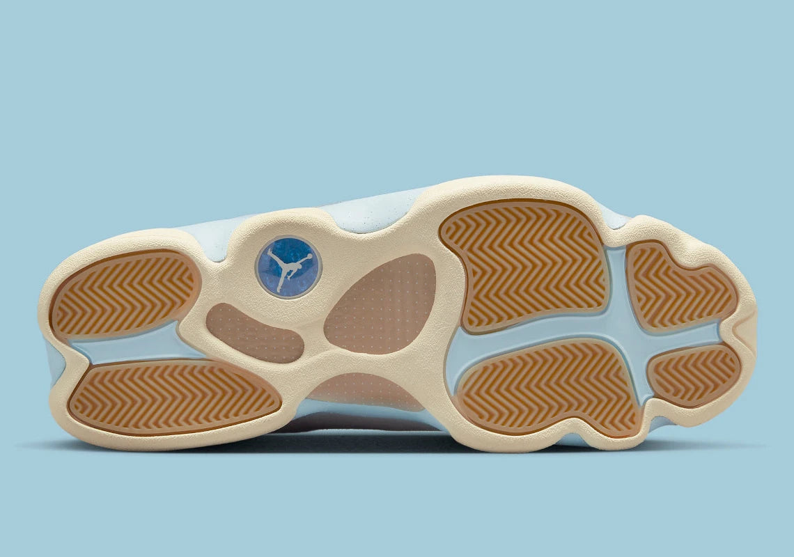 Air Jordan 13 Retro SoleFly DX5763-100 en suède et ripstop blanc, gris et bleu ciel avec hologramme cat’s eye et semelle gum vue de dessous. 