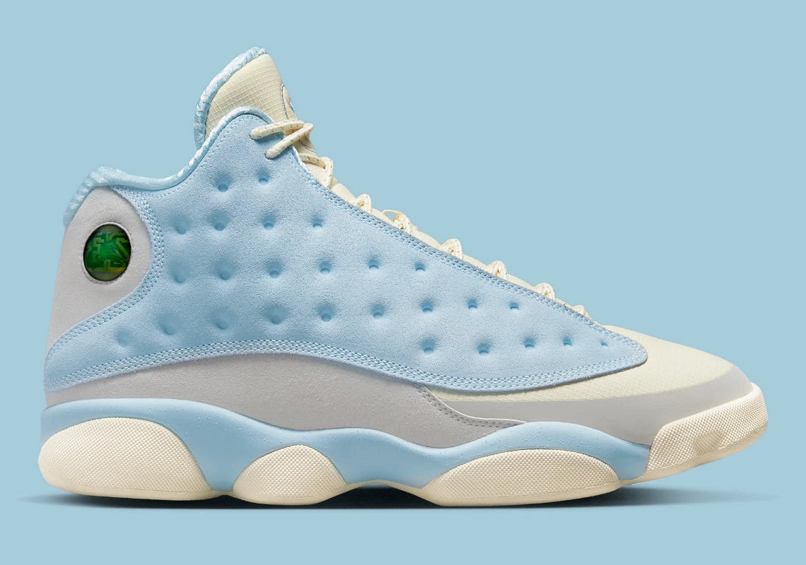 Air Jordan 13 Retro SoleFly DX5763-100 en suède et ripstop blanc, gris et bleu ciel avec hologramme cat’s eye et semelle gum vue de profil. 