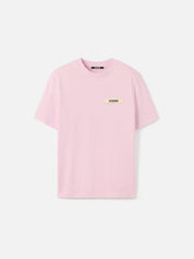 Tee-shirt JACQUEMUS Gros Grain rose clair en coton premium, avec col rond côtelé, détail Gros Grain signature et coupe régulière au style minimaliste.