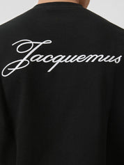 T-shirt Jacquemus en coton noir premium avec logo script blanc, au design minimaliste et élégant.
