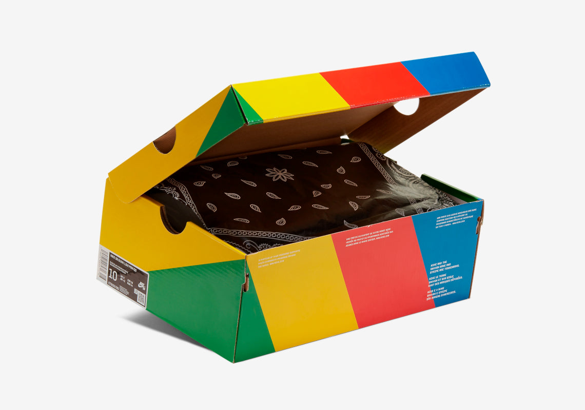 Sneakers Nike SB Dunk Low Travis Scott en suède, cuir et toile, coloris beige, marron et noir, swoosh inversé et détails premium.Vue de la boite