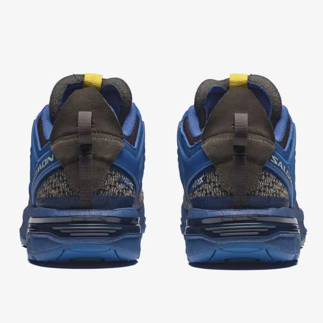 Salomon ACS Pro A-COLD-WALL Bluing Earth Brown avec tige en mesh technique respirant, cage synthétique structurée, système Quicklace™ et semelle extérieure Contagrip® vue de derrière. 