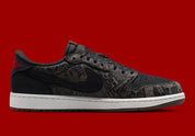Air Jordan 1 Retro Low OG Laser Black University Red, sneaker noire en cuir gravé au laser avec détails marron, talon rouge et semelle blanche.