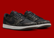 Air Jordan 1 Retro Low OG Laser Black University Red, sneaker noire en cuir gravé au laser avec détails marron, talon rouge et semelle blanche.