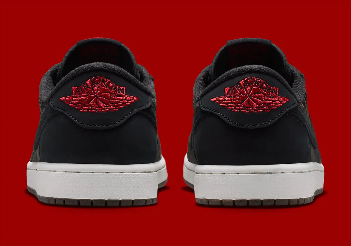 Air Jordan 1 Retro Low OG Laser Black University Red, sneaker noire en cuir gravé au laser avec détails marron, talon rouge et semelle blanche.