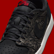 Air Jordan 1 Retro Low OG Laser Black University Red, sneaker noire en cuir gravé au laser avec détails marron, talon rouge et semelle blanche.