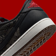 Air Jordan 1 Retro Low OG Laser Black University Red, sneaker noire en cuir gravé au laser avec détails marron, talon rouge et semelle blanche.