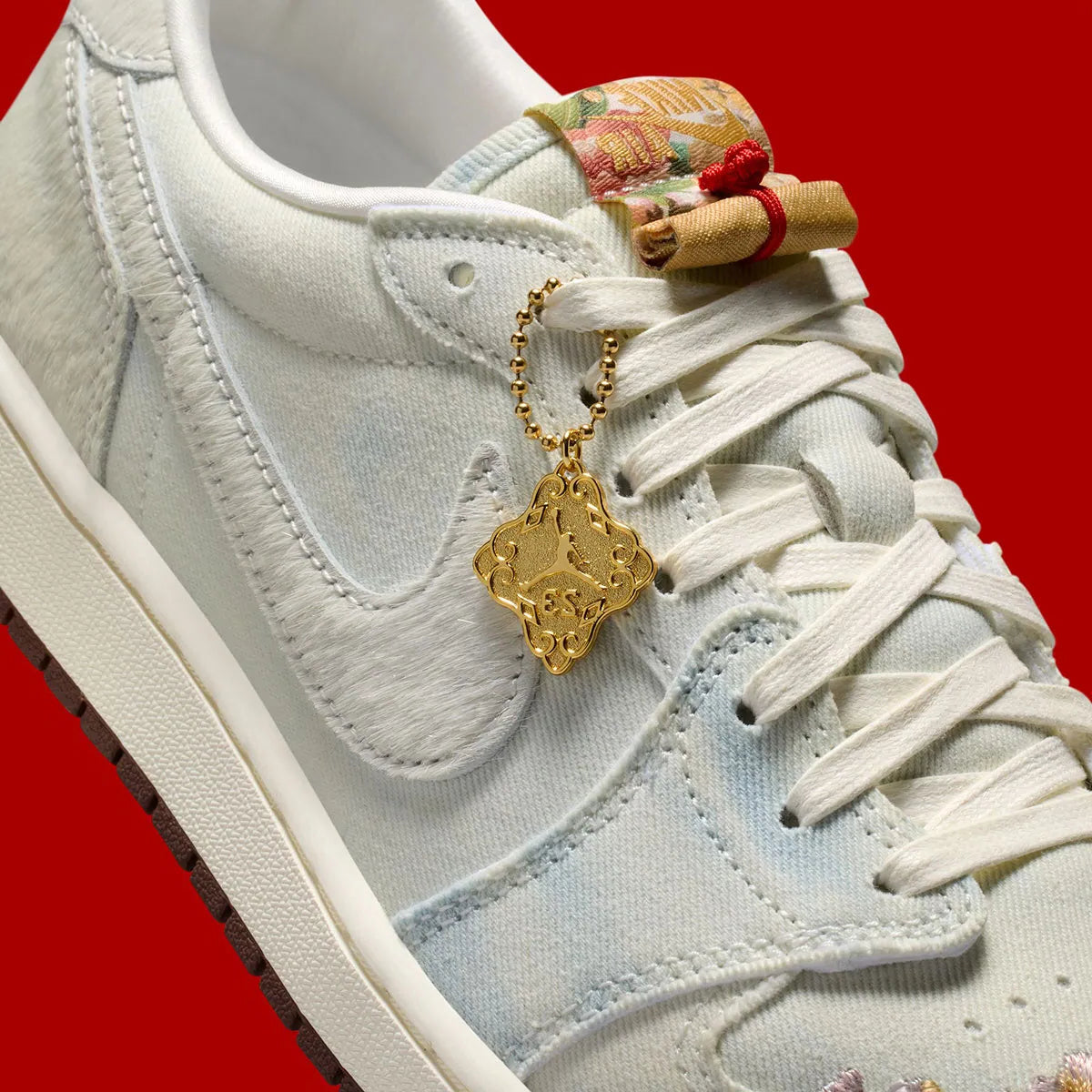Sneakers Air Jordan 1 Retro Low OG en cuir premium avec détails brodés inspirés du Nouvel An chinois, coloris rouge et accents dorés, édition collector 2026.

