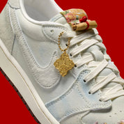 Sneakers Air Jordan 1 Retro Low OG en cuir premium avec détails brodés inspirés du Nouvel An chinois, coloris rouge et accents dorés, édition collector 2026.

