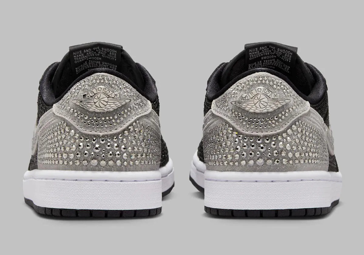 Image de la Jordan 1 Retro Low OG Swarovski Stealth pour femme, sneaker en cuir gris avec Swoosh incrusté de cristaux Swarovski et semelle Air encapsulée. Vue de derrière. 
