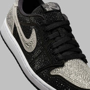 Image de la Jordan 1 Retro Low OG Swarovski Stealth pour femme, sneaker en cuir gris avec Swoosh incrusté de cristaux Swarovski et semelle Air encapsulée. Vue zoomée sur le profil de la paire. 