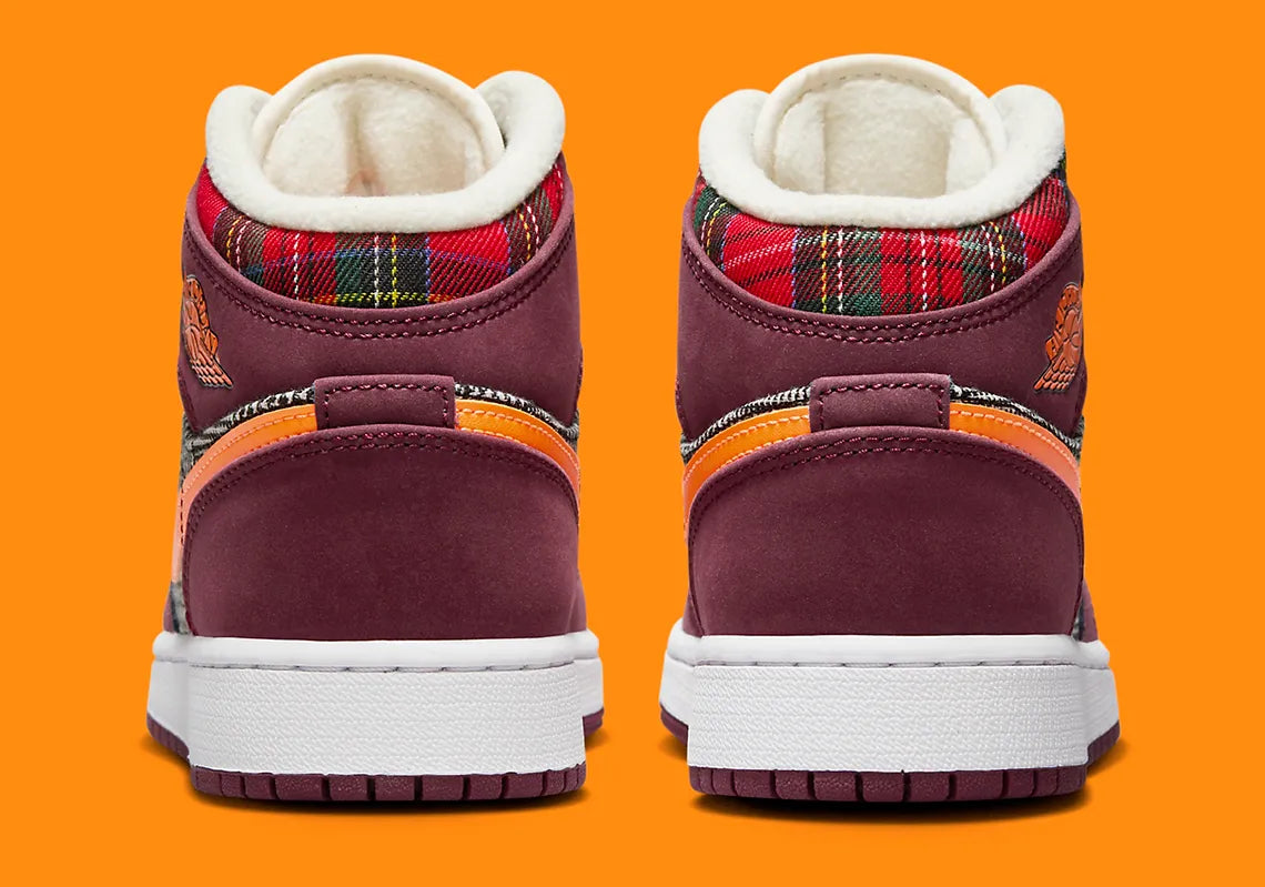 Air Jordan 1 Mid SE Plaid, sneaker mi-montante bordeaux, noire et blanche avec panneaux à carreaux tartan et détails orange.
