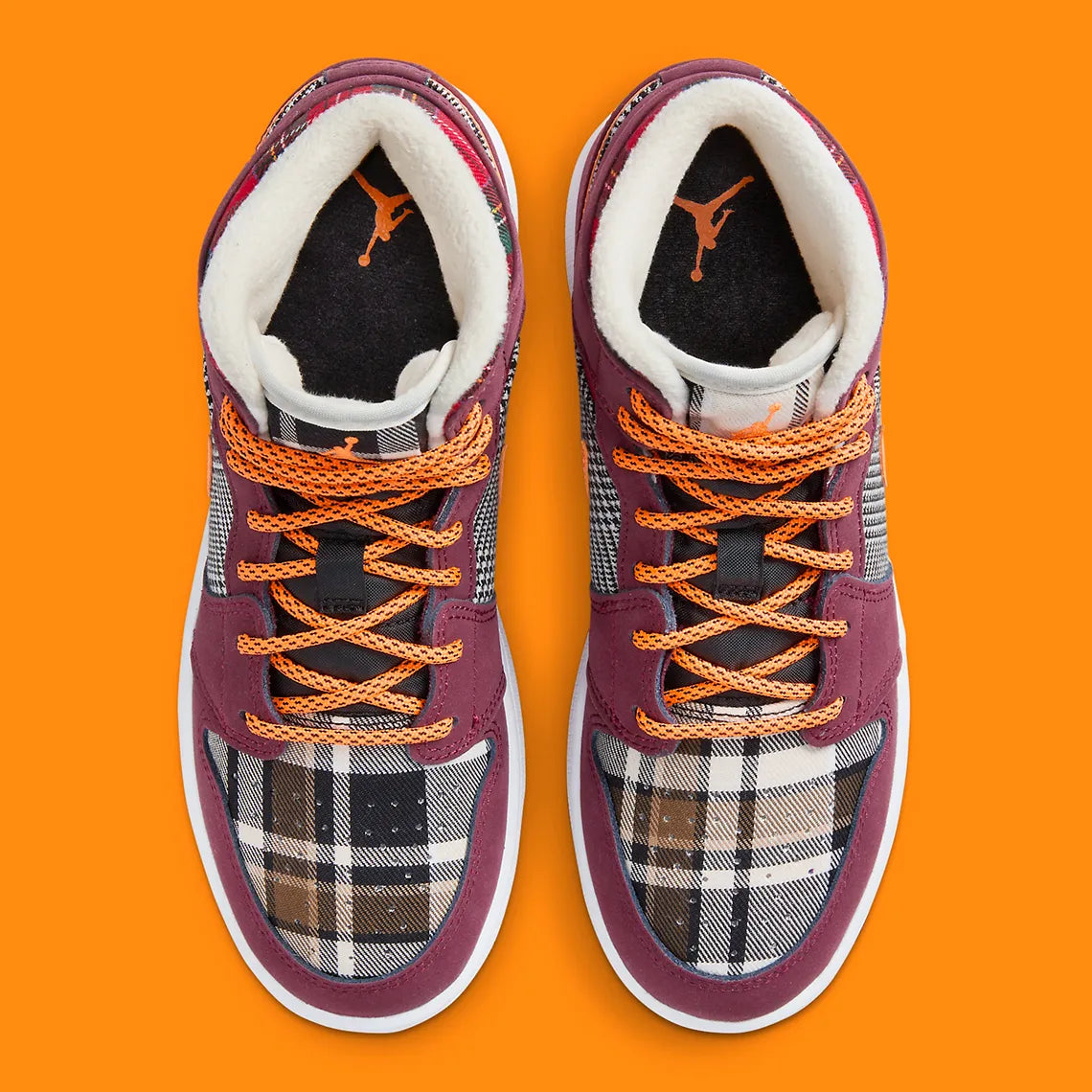 Air Jordan 1 Mid SE Plaid, sneaker mi-montante bordeaux, noire et blanche avec panneaux à carreaux tartan et détails orange.