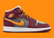 Air Jordan 1 Mid SE Plaid, sneaker mi-montante bordeaux, noire et blanche avec panneaux à carreaux tartan et détails orange.