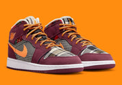 Air Jordan 1 Mid SE Plaid, sneaker mi-montante bordeaux, noire et blanche avec panneaux à carreaux tartan et détails orange.