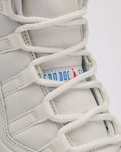 Détails sur la languette de la sneakers Air Jordan 11 Retro 285 en cuir verni et mesh technique avec semelle translucide et amorti Air iconique