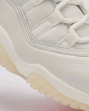 Vue zoomée sur le cuir de la sneakers Air Jordan 11 Retro 285 en cuir verni et mesh technique avec semelle translucide et amorti Air iconique