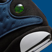 Vue zoomée sur les détails arrières de la Air Jordan 13 Retro Brave Blue DJ5982-400 en bleu marine et noir avec détails blancs, Jumpman University Blue et hologramme latéral.