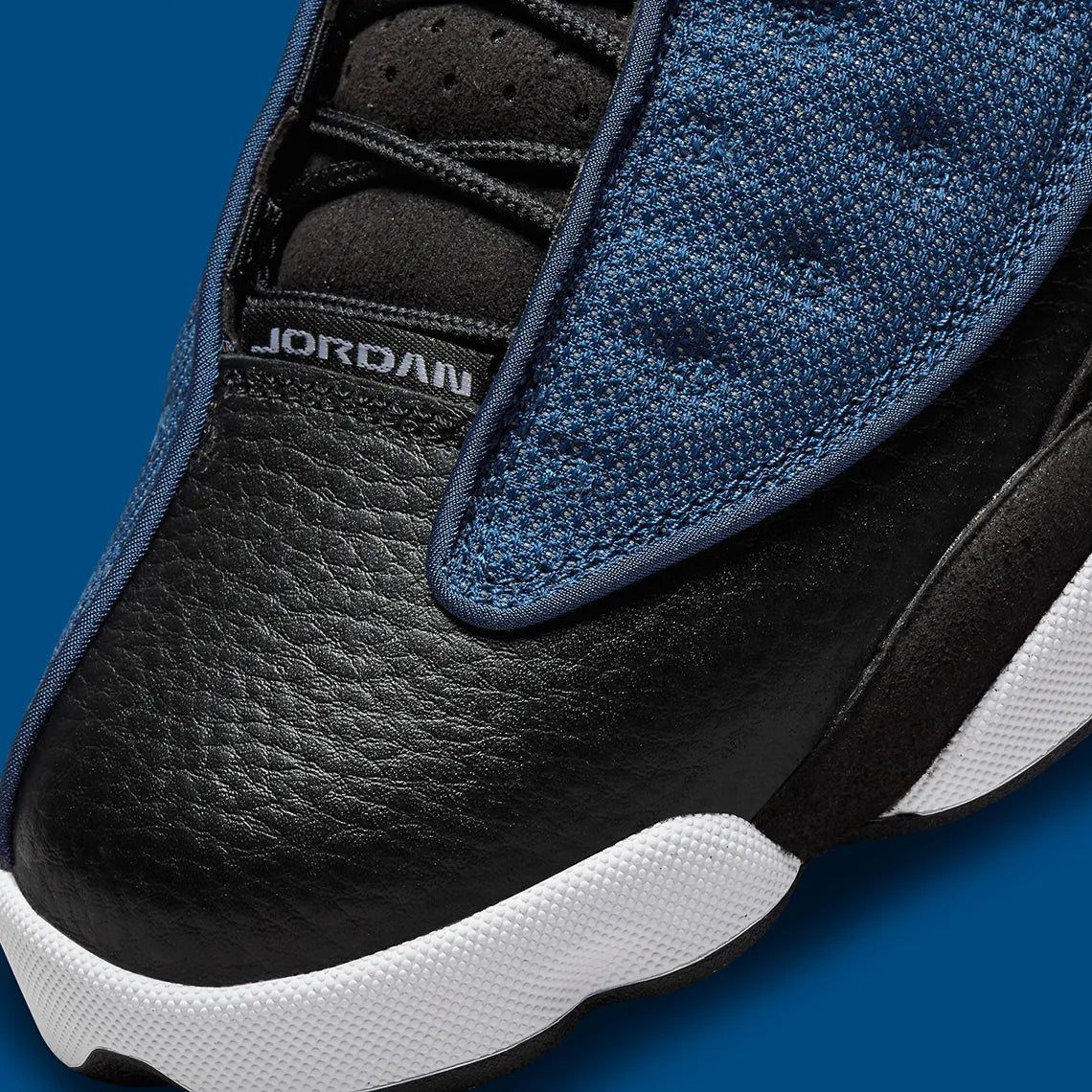 Vue zoomée sur la toe box de la Air Jordan 13 Retro Brave Blue DJ5982-400 en bleu marine et noir avec détails blancs, Jumpman University Blue et hologramme latéral.