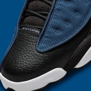 Vue zoomée sur la toe box de la Air Jordan 13 Retro Brave Blue DJ5982-400 en bleu marine et noir avec détails blancs, Jumpman University Blue et hologramme latéral.