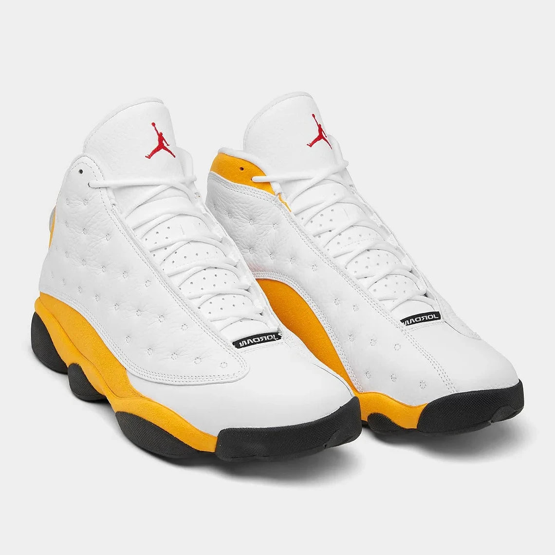 Air Jordan 13 Retro Del Sol 414571-167 en cuir blanc avec accents jaunes Del Sol, détails rouges, noirs et hologramme latéral vert vue de 3/4 face. 