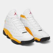 Air Jordan 13 Retro Del Sol 414571-167 en cuir blanc avec accents jaunes Del Sol, détails rouges, noirs et hologramme latéral vert vue de 3/4 face. 