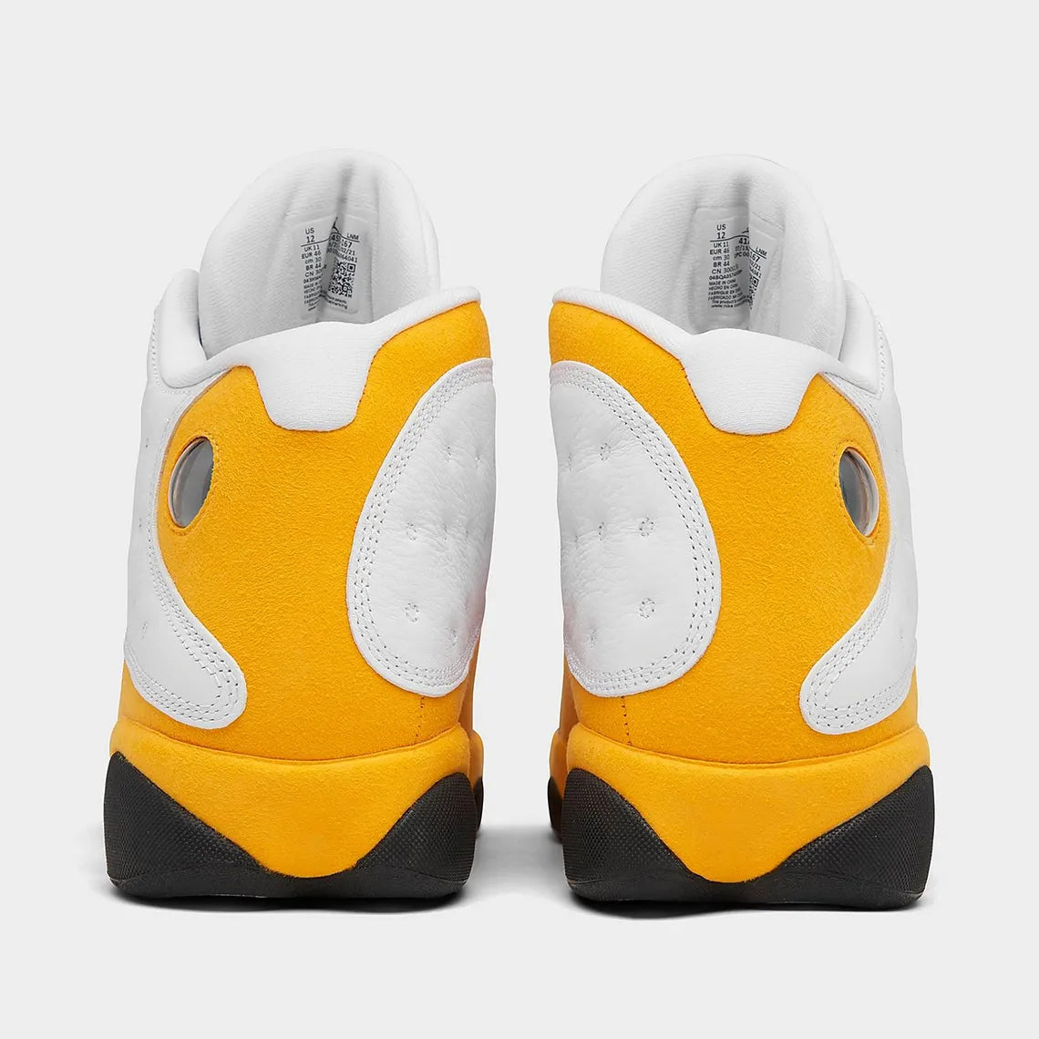 Air Jordan 13 Retro Del Sol 414571-167 en cuir blanc avec accents jaunes Del Sol, détails rouges, noirs et hologramme latéral vert vue de derrière. 