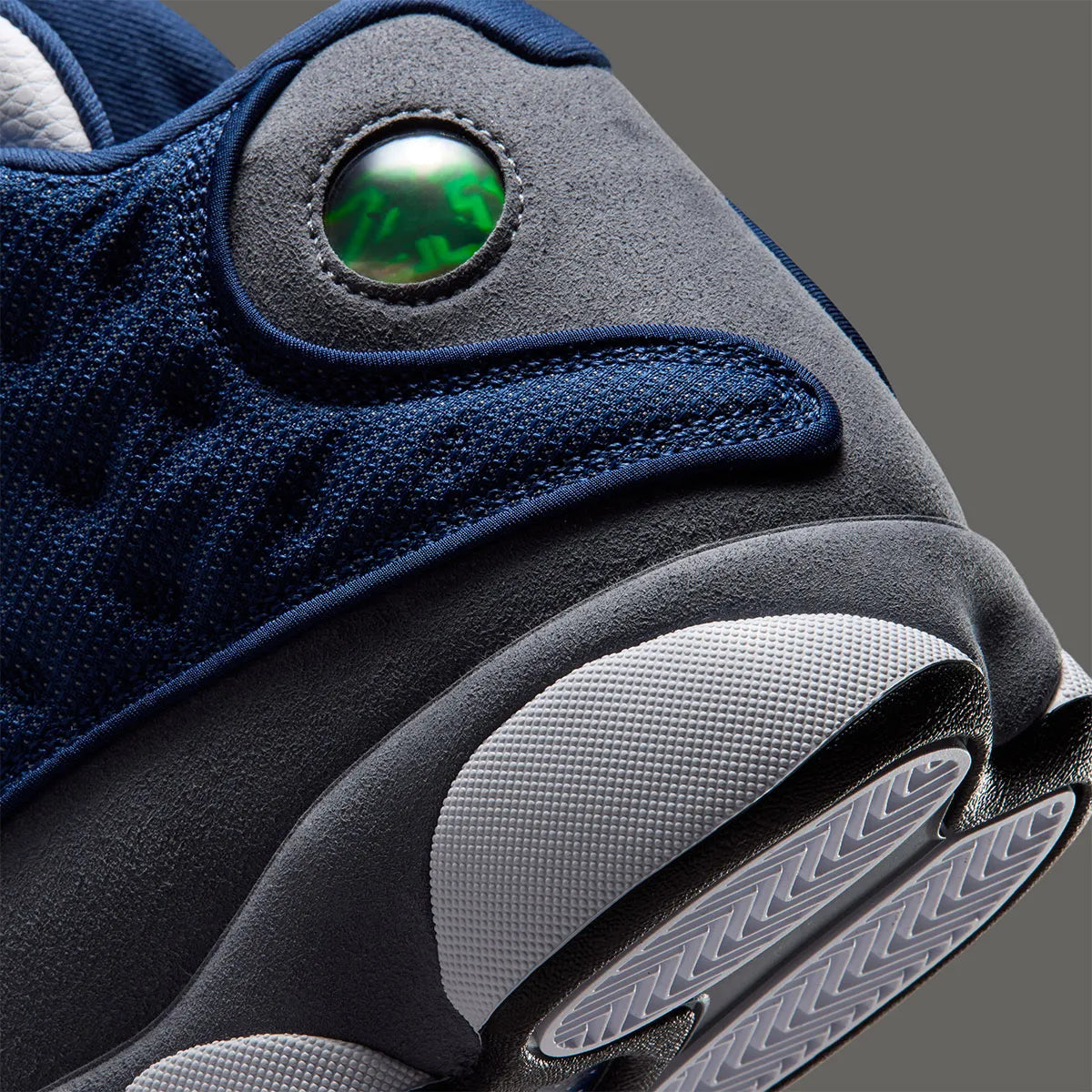 Air Jordan 13 Retro Flint 2026, sneaker Jordan Brand en cuir blanc, mesh réfléchissant bleu marine et suède Flint Grey avec amorti Zoom Air et œil holographique.