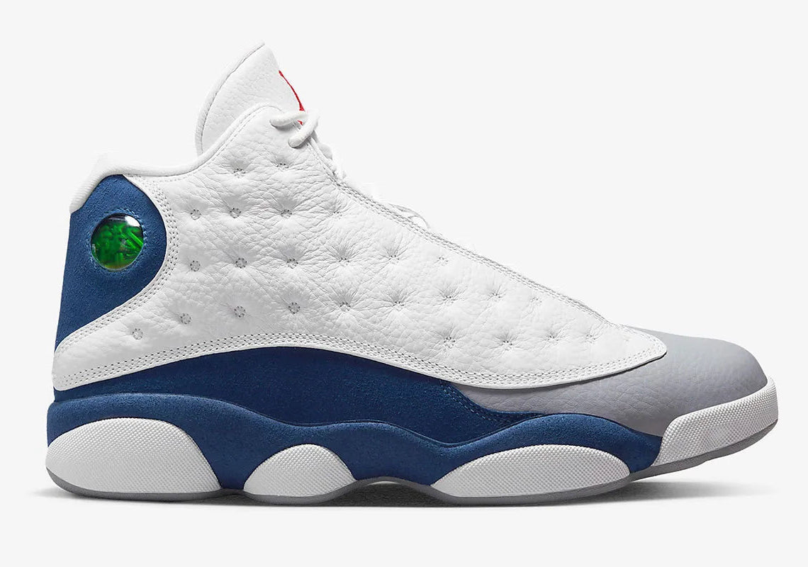 Air Jordan 13 Retro French Blue 414571-164 en cuir blanc avec panneaux French Blue, avant-pied gris, Jumpman rouge et hologramme latéral vue de profil. 