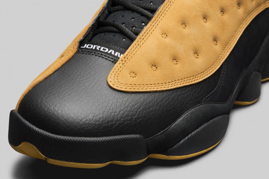 Vue zoomée sur la toe box de la Air Jordan 13 Retro Low Chutney 310810-022 en cuir noir avec panneaux en suède brun Chutney, semelle segmentée et silhouette basse.