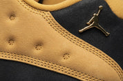Vue zoomée sur le jumpman de la Air Jordan 13 Retro Low Chutney 310810-022 en cuir noir avec panneaux en suède brun Chutney, semelle segmentée et silhouette basse.