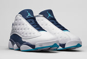 Air Jordan 13 Retro Low Hornets 310810-107 en cuir blanc avec empiècements Midnight Navy, accents Turquoise Blue et Jumpman métallique vue de 3/4 face. 