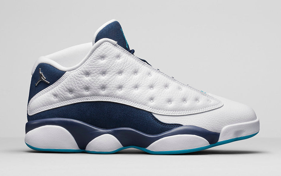 Air Jordan 13 Retro Low Hornets 310810-107 en cuir blanc avec empiècements Midnight Navy, accents Turquoise Blue et Jumpman métallique vue de profil. 