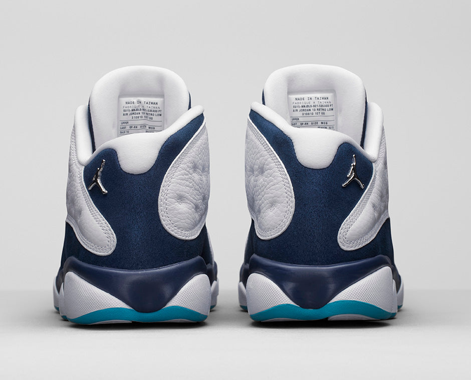 Air Jordan 13 Retro Low Hornets 310810-107 en cuir blanc avec empiècements Midnight Navy, accents Turquoise Blue et Jumpman métallique vue de derrière. 