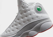 Vue zoomée sur les détails latéraux de la Air Jordan 13 Retro Wolf Grey 414571-160 en cuir blanc avec panneaux Wolf Grey, détails True Red, semelle segmentée et hologramme vert.