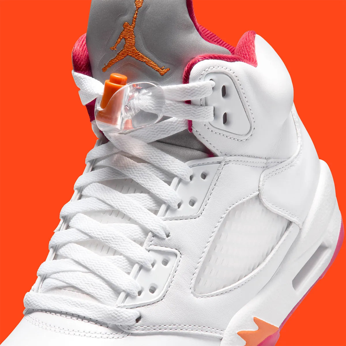 Vue zoomée sur les détails latéraux de la Air Jordan 5 Retro Sunset 2026 IV5678-102 en cuir blanc avec languette Metallic Silver, accents orange Sunset et détails Fire Red.